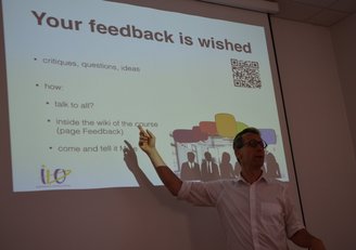 Mann trägt vor, auf der Präsentationsfolie steht "Your feedback is wished"