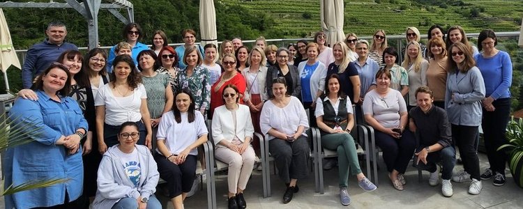 Ein Foto aller 42 Lehrer/innen auf der TErrasse des Hotel Steigenberger in Krems. Im Hintergrund sind die Weinhügel zu sehen