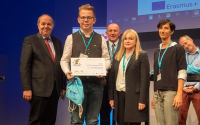 Teilnehmer/innen auf der Bühne der ECVET-Konferenz 2017. Mit einem Check in der Hand.