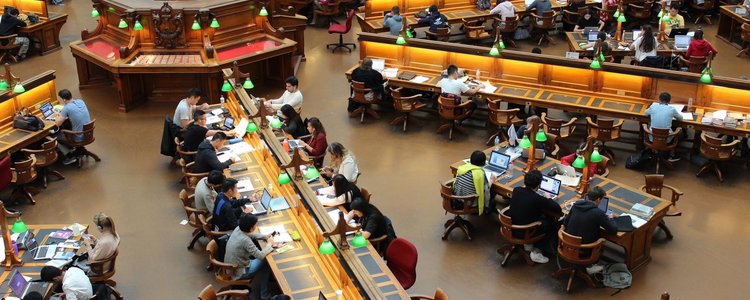 Studierende an Tischen in Bibliothek von oben fotografiert