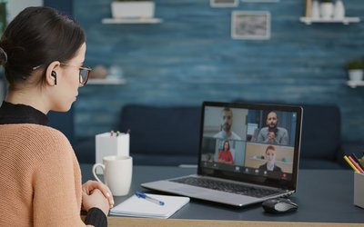 University student attending video call meeting with people on online school class, using laptop at home. Woman having conversation on remote teleconference, webinar learning chat.