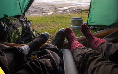 2 Paar Füße in Wollsocken ragen aus einem Zelt