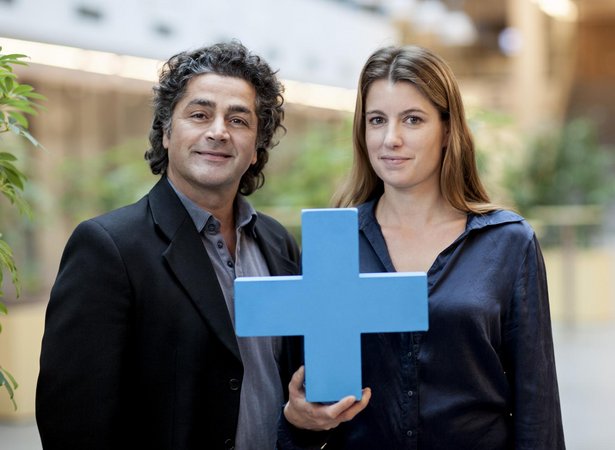 Mann und Frau halten blaues Erasmus Plus Symbol in die Kamera