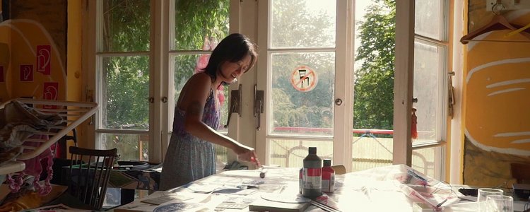 Eine junge Frau malt an einem Tisch