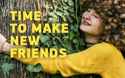 Eine junge Frau umarmt einen Baum. Daneben ist der Schriftzug: "Time to make new friends".