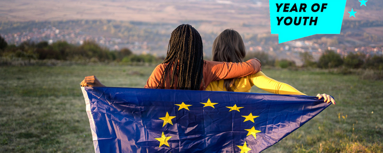 Zwei Frauen halten die EU Flagge und blicken in die Ferne