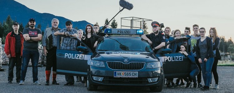 Schülerinnen und Schüler bei den Dreharbeiten vor einem Polizeiauto mit dem Kennzeichen "VK"