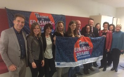 Gruppenbild Vertreter/innen der finnischen Delegation und der Nationalagentur halten Erasmus+ Flagge