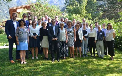 Die Teilnehmer/innen der OeAD-Veranstaltung beim Europäischen Forum Alpbach stehen in einer grünen Wiese und blicken zum Fotografen.