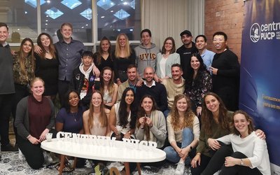 Gruppenfoto von etwa 25 internationalen Studierenden, die in einem Raum posieren